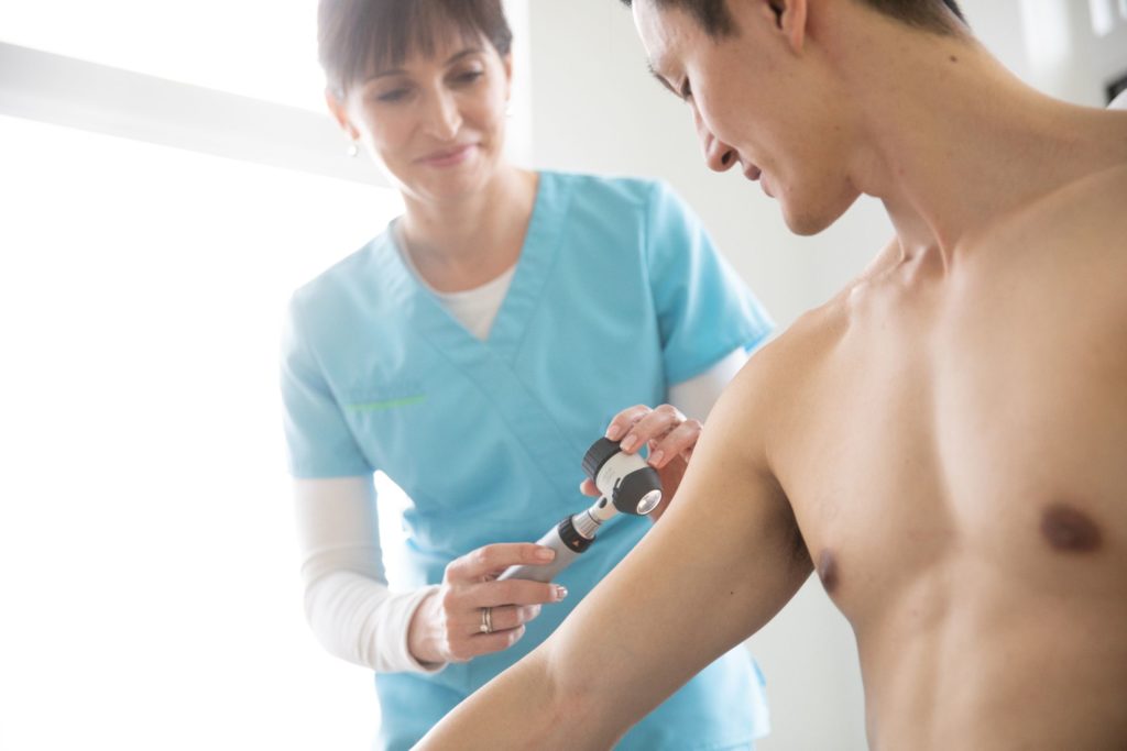 Dr Lize Wiese assessing a patient's skin.